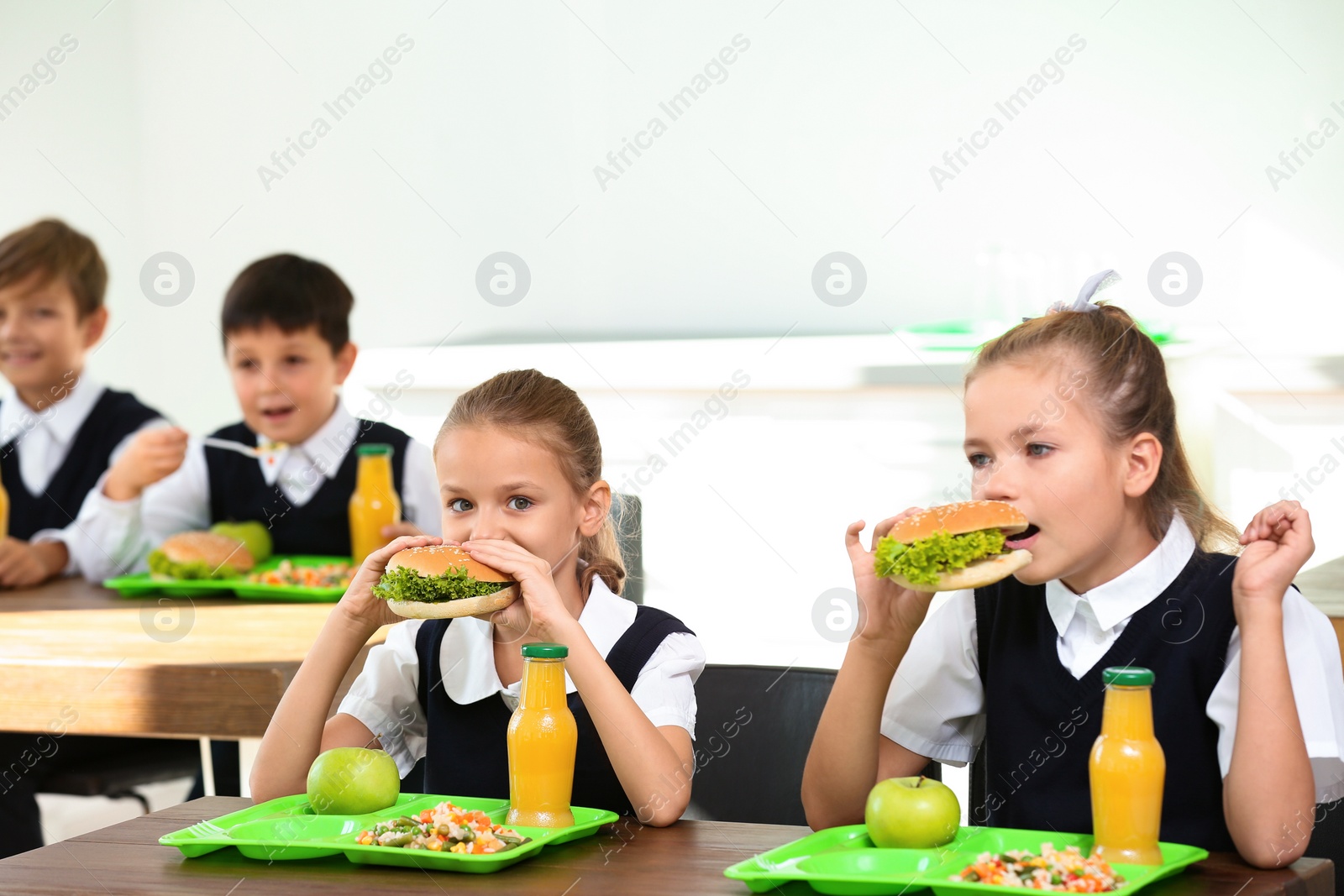 Photo of Happy children eating healthy food for lunch in school canteen