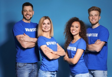 Team of volunteers in uniform on blue background