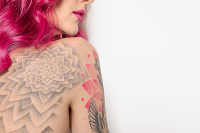 Beautiful woman with tattoos on body against white background, closeup. Space for text