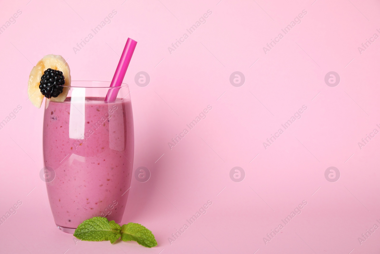 Photo of Glass of delicious blackberry smoothie on pink background. Space for text