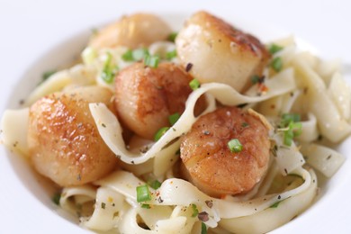 Photo of Delicious scallop pasta with spices in bowl, closeup