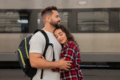 Photo of Long-distance relationship. Beautiful couple hugging on platform of railway station