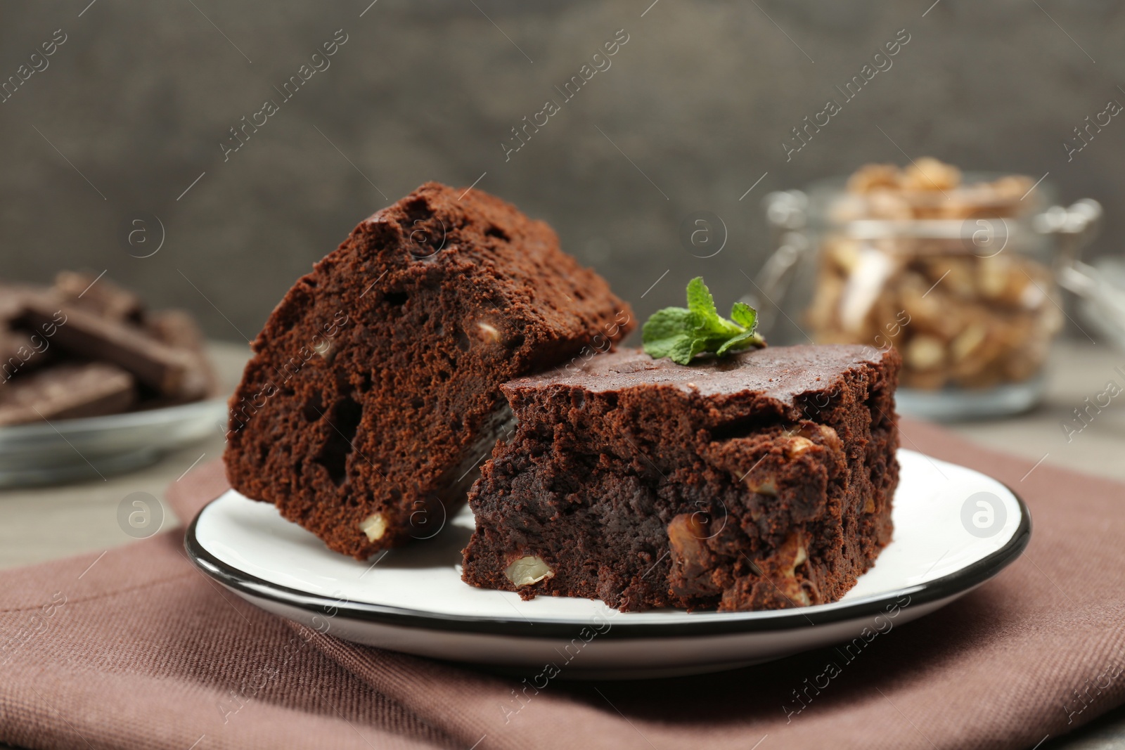 Photo of Delicious brownies with nuts and mint on table, closeup