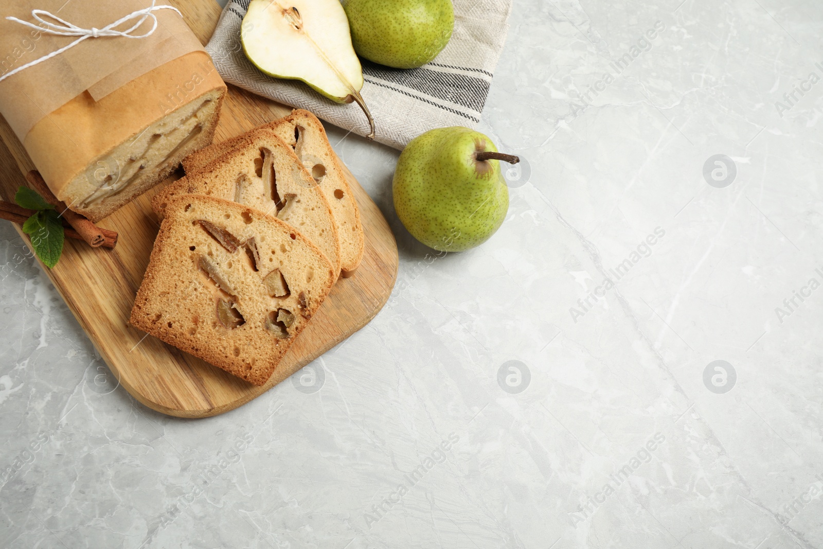 Photo of Tasty bread and pears on light grey marble table, flat lay with space for text. Homemade cake