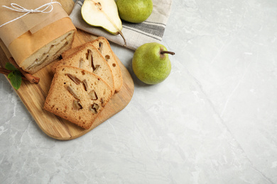 Photo of Tasty bread and pears on light grey marble table, flat lay with space for text. Homemade cake