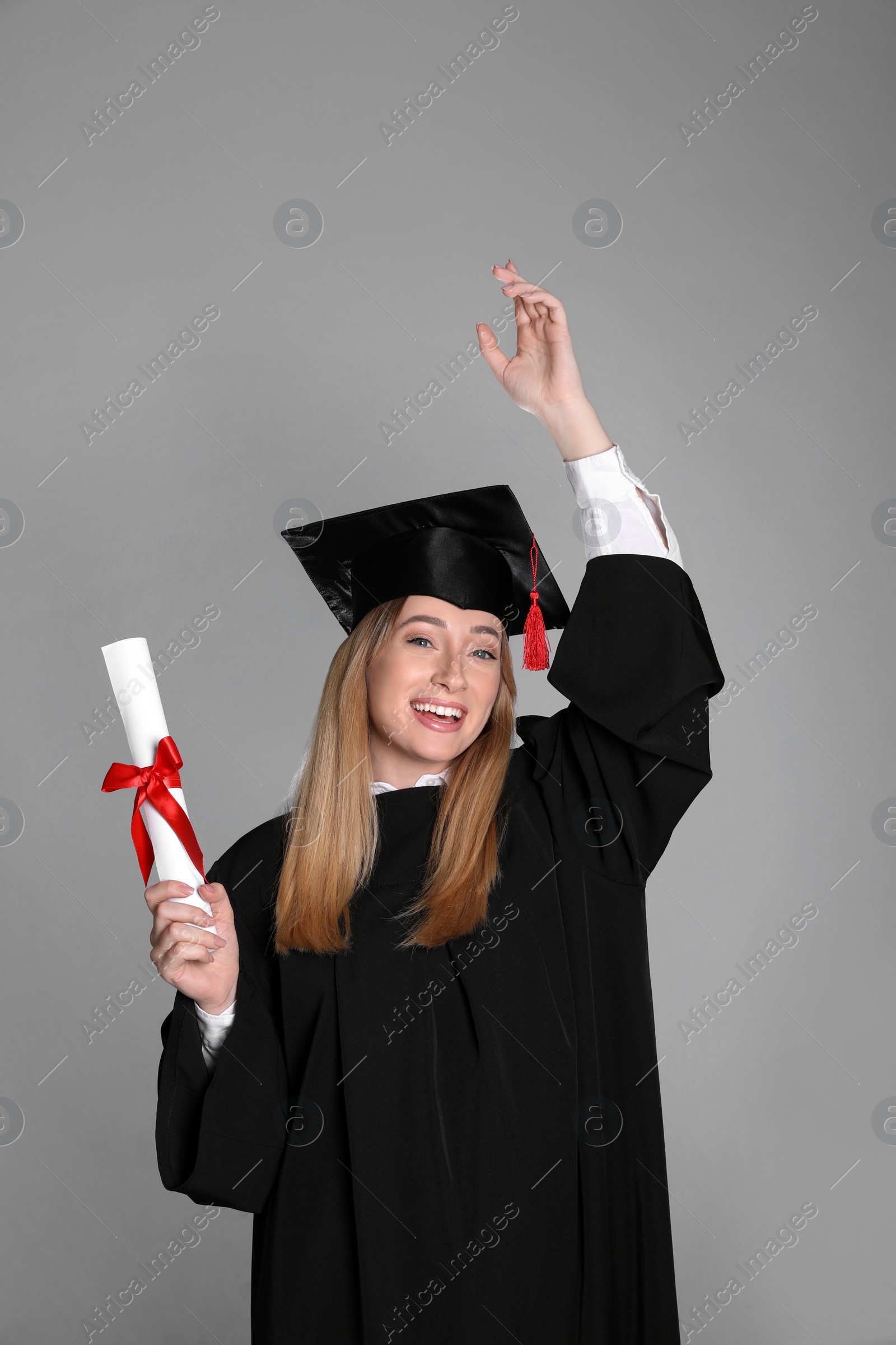 Photo of Happy student with diploma on grey background