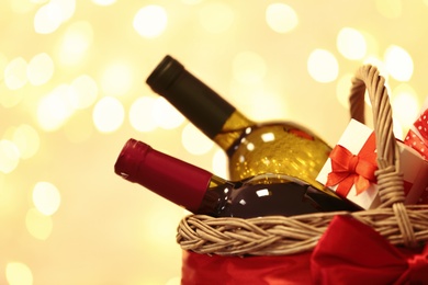 Photo of Gift basket with bottles of wine against blurred lights