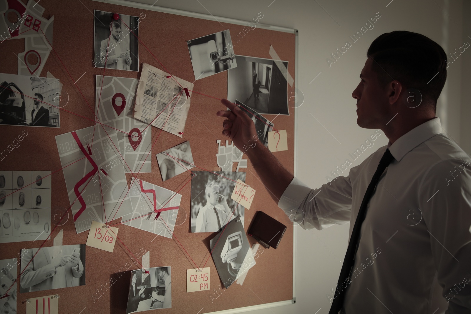 Photo of Detective looking at evidence board in office