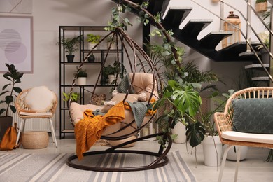 Indoor terrace interior with hanging chair and green plants