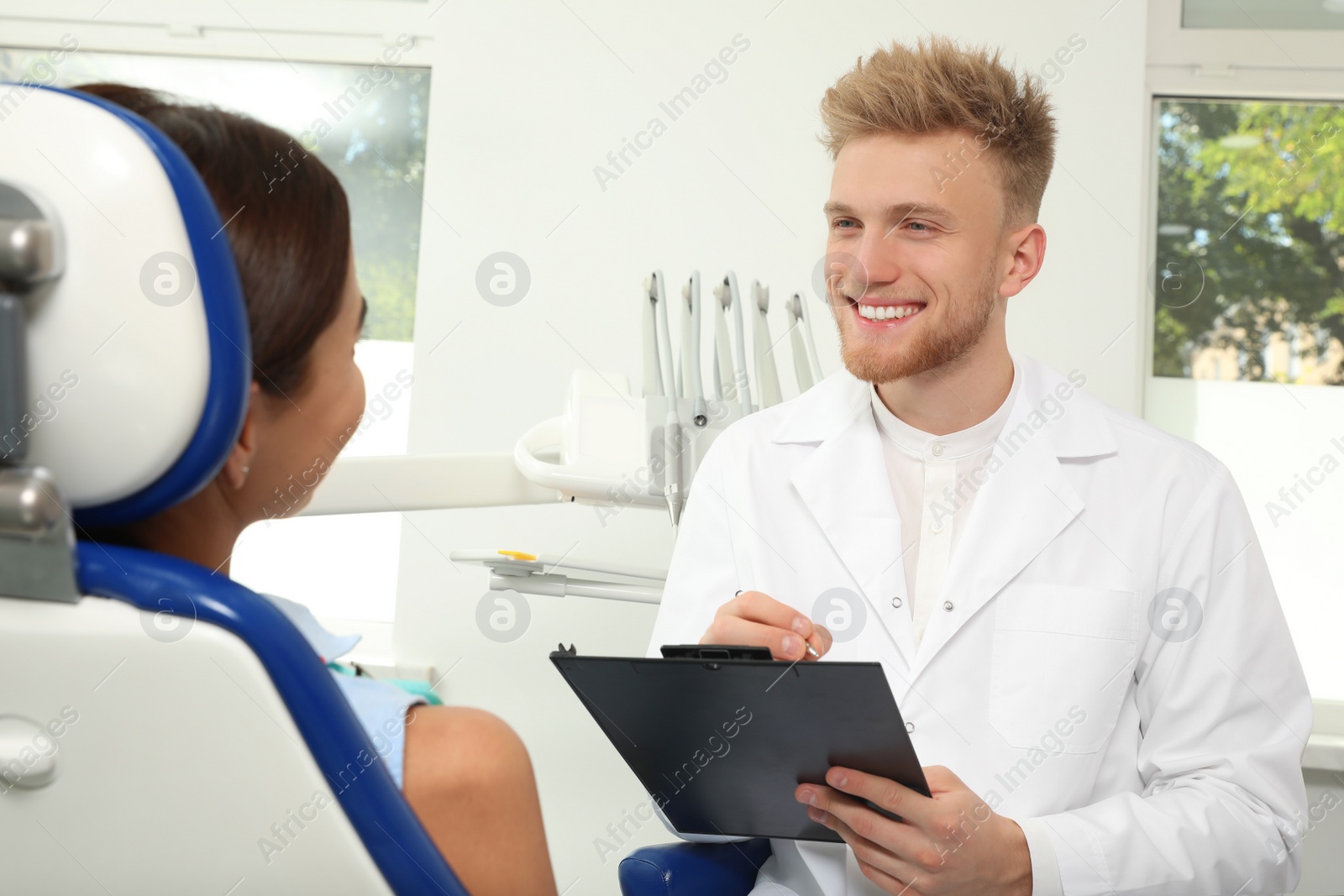 Photo of Professional dentist working with patient in clinic