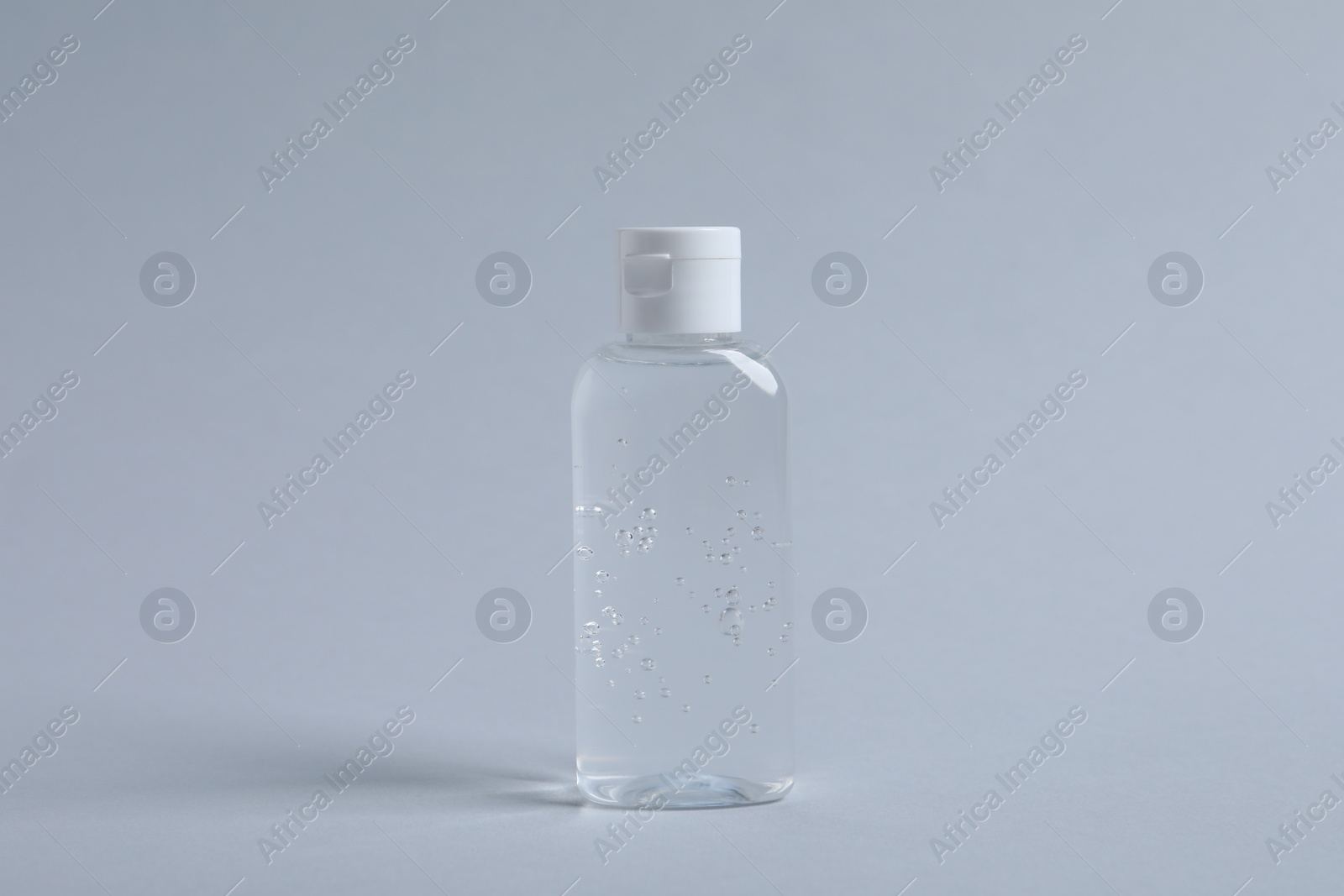 Photo of Bottle of cosmetic product on light grey background