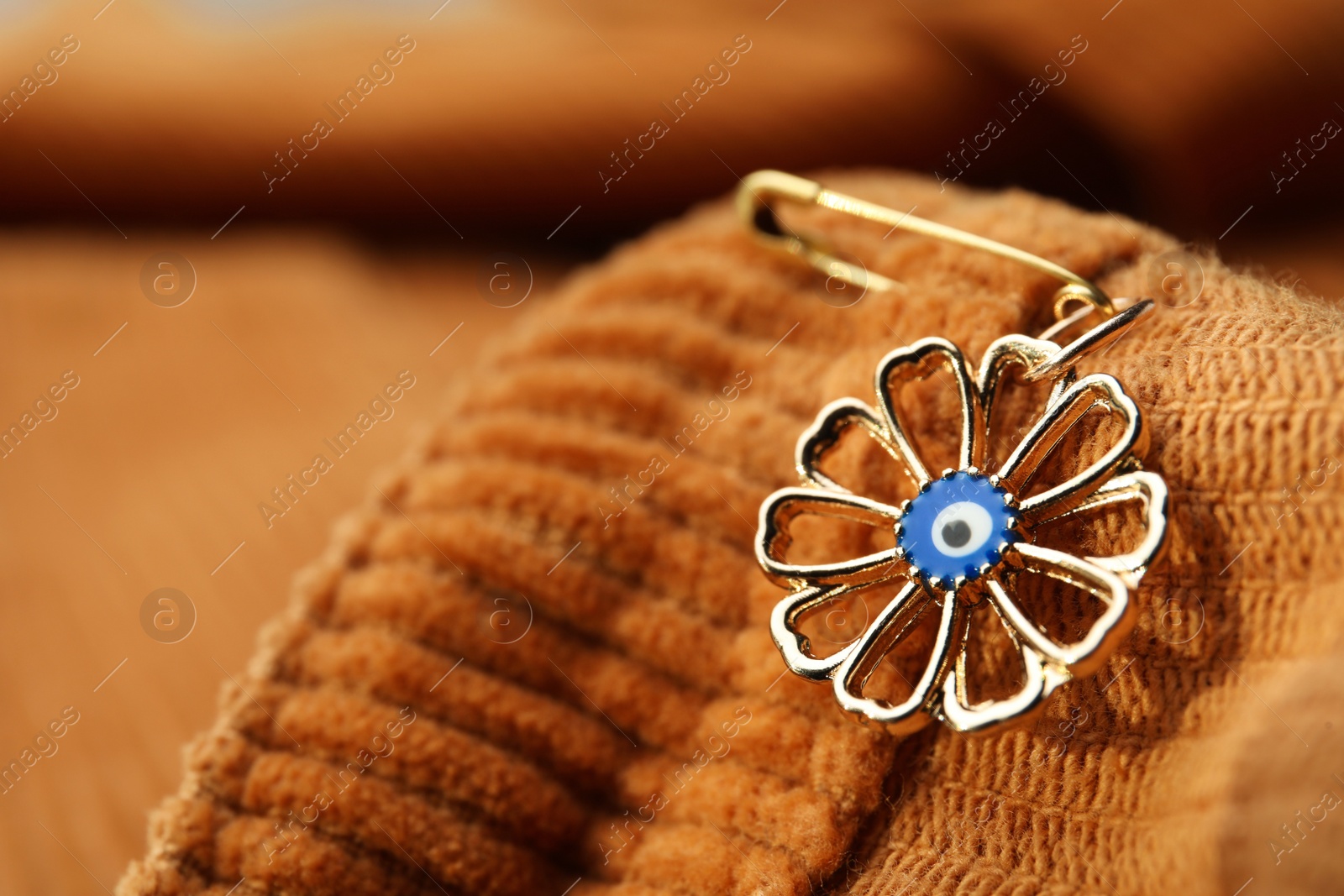 Photo of Evil eye safety pin on clothing, closeup