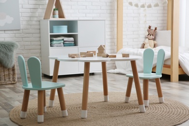 Little table and chairs with bunny ears in children's room. Interior design