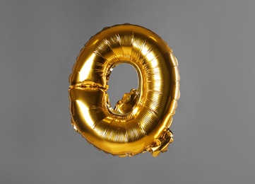Photo of Golden letter Q balloon on grey background
