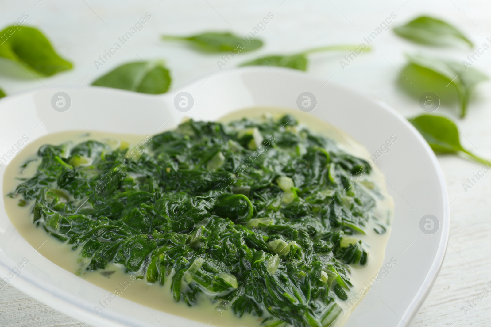 Photo of Tasty spinach dip on white table, closeup