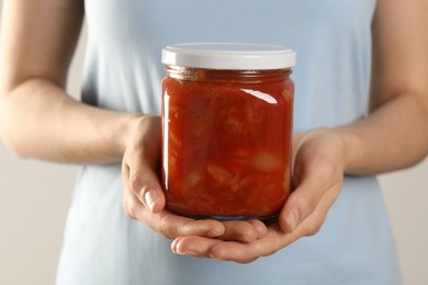 Photo of Woman holding jar of canned lecho, closeup