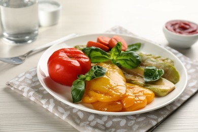 Delicious grilled vegetables with basil on white wooden table, closeup