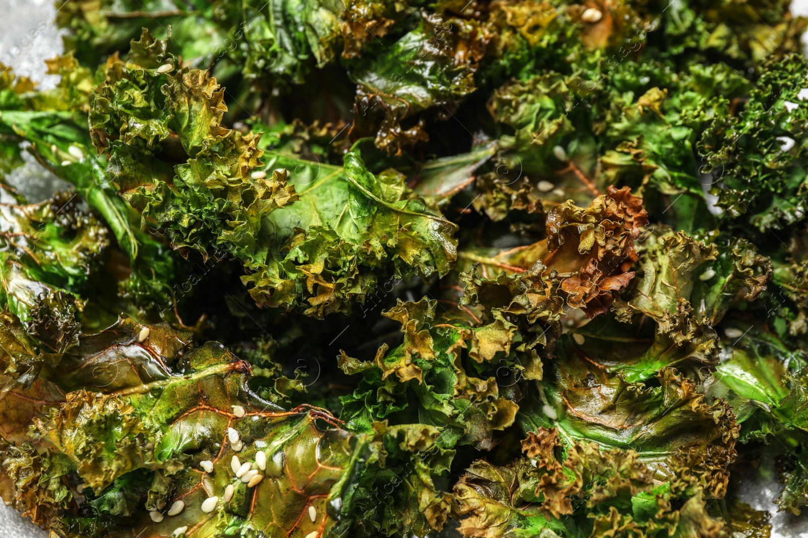 Photo of Tasty baked kale chips as background, closeup