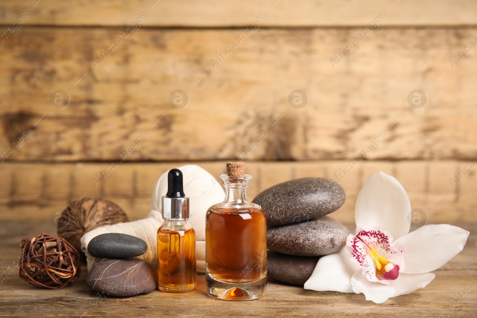 Photo of Beautiful spa composition with essential oil and orchid flower on wooden table, space for text