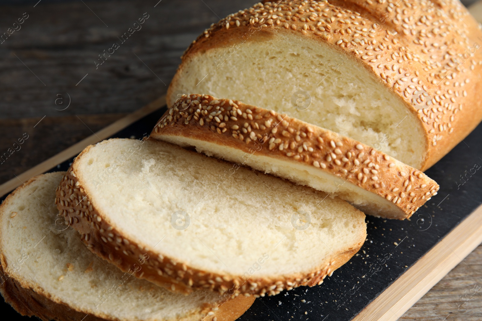 Photo of Tasty wheat bread on wooden board, closeup