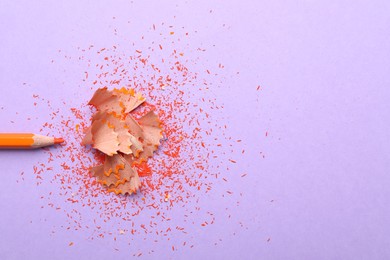 Photo of Pencil and shavings on violet background, flat lay. Space for text