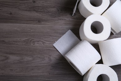 Photo of Soft toilet paper rolls on wooden table, flat lay. Space for text