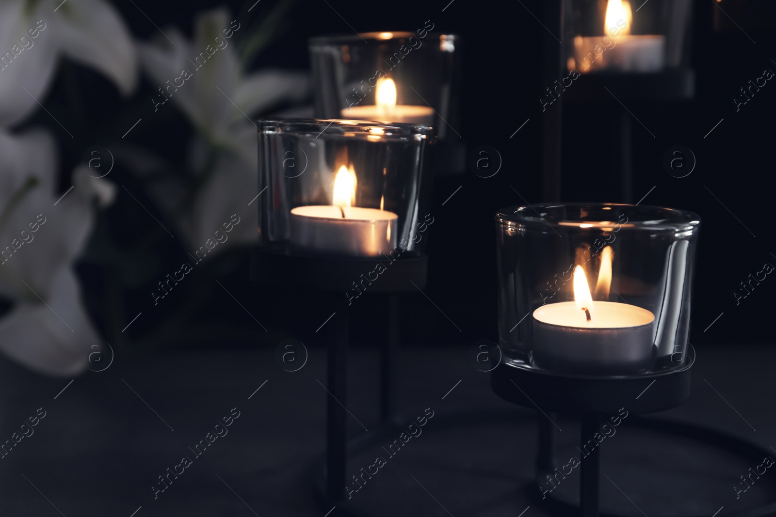 Photo of Burning candles on dark background. Funeral symbol