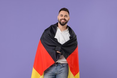 Photo of Young man with flag of Germany on purple background