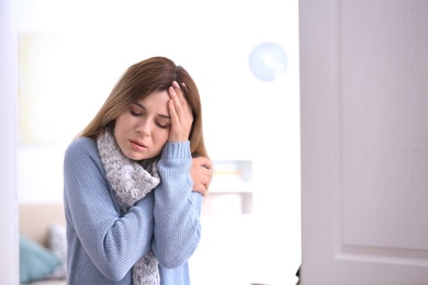 Photo of Woman with headache suffering from cold on blurred background