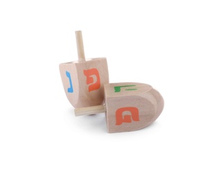 Wooden Hanukkah traditional dreidels with letters Pe, Nun and He on white background