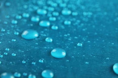 Many clean water drops on color background