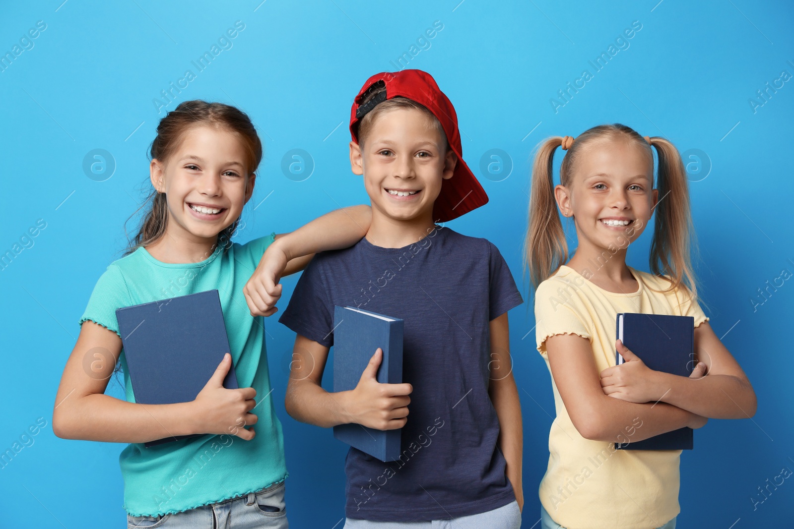 Photo of Little children with books on blue background. Reading concept
