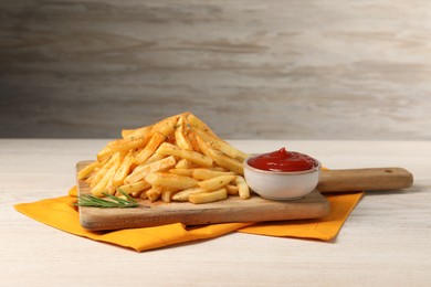 Delicious french fries served with sauce on white wooden table