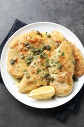 Photo of Delicious chicken piccata with herbs on grey table, top view