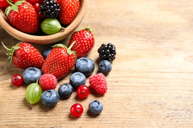 Photo of Mix of ripe berries on wooden table, closeup