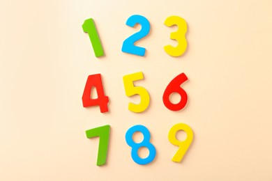 Photo of Colorful numbers on beige background, flat lay