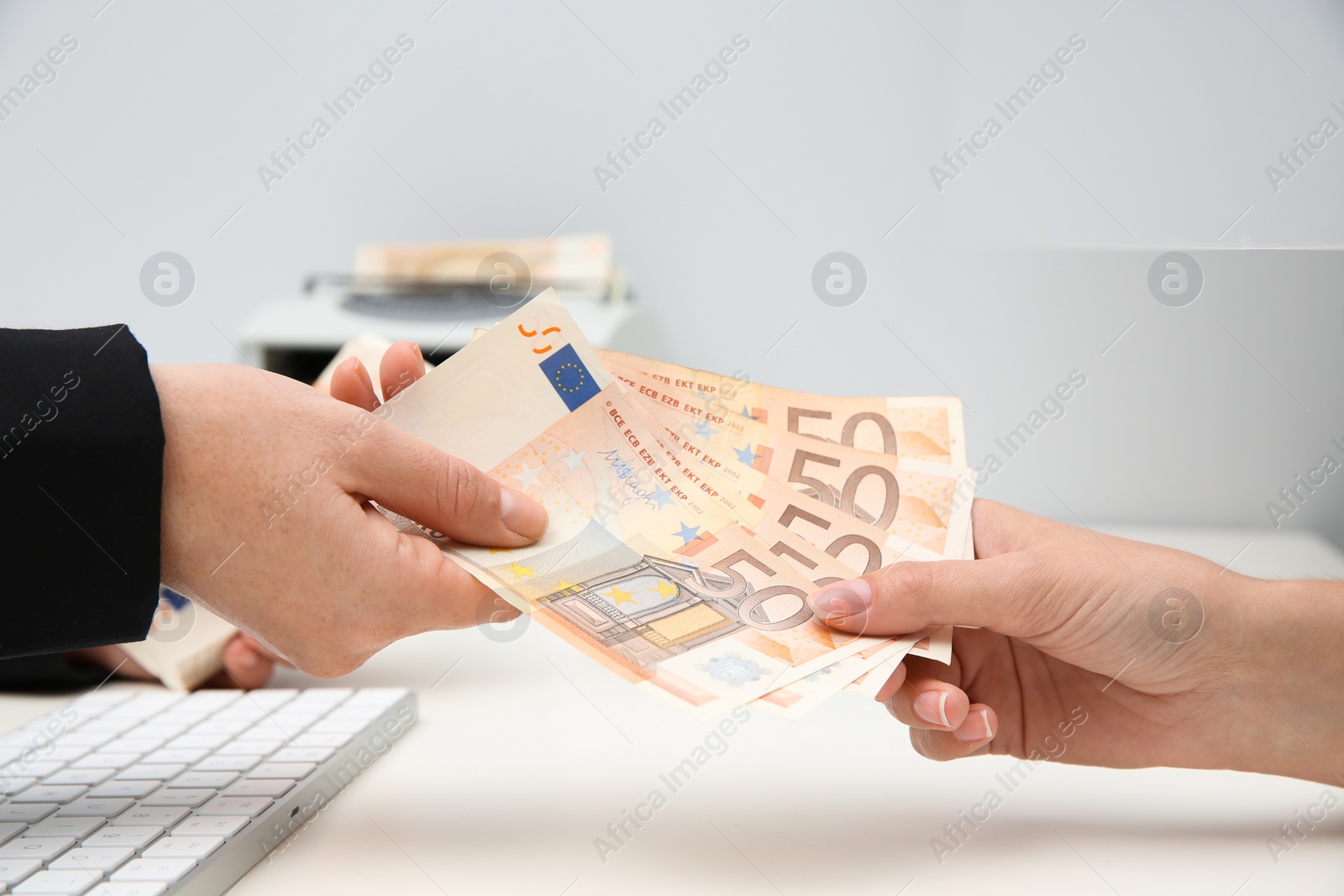 Photo of Woman receiving money from teller at cash department window, closeup