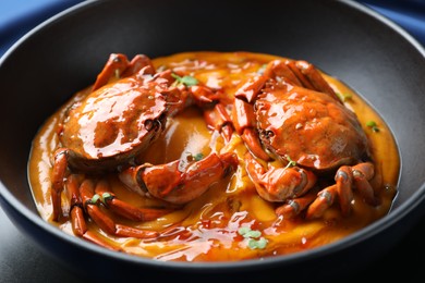 Photo of Delicious boiled crabs with sauce in bowl, closeup
