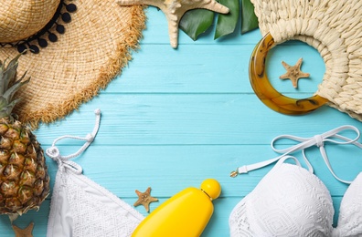 Flat lay composition with beach objects on light blue wooden background. Space for text