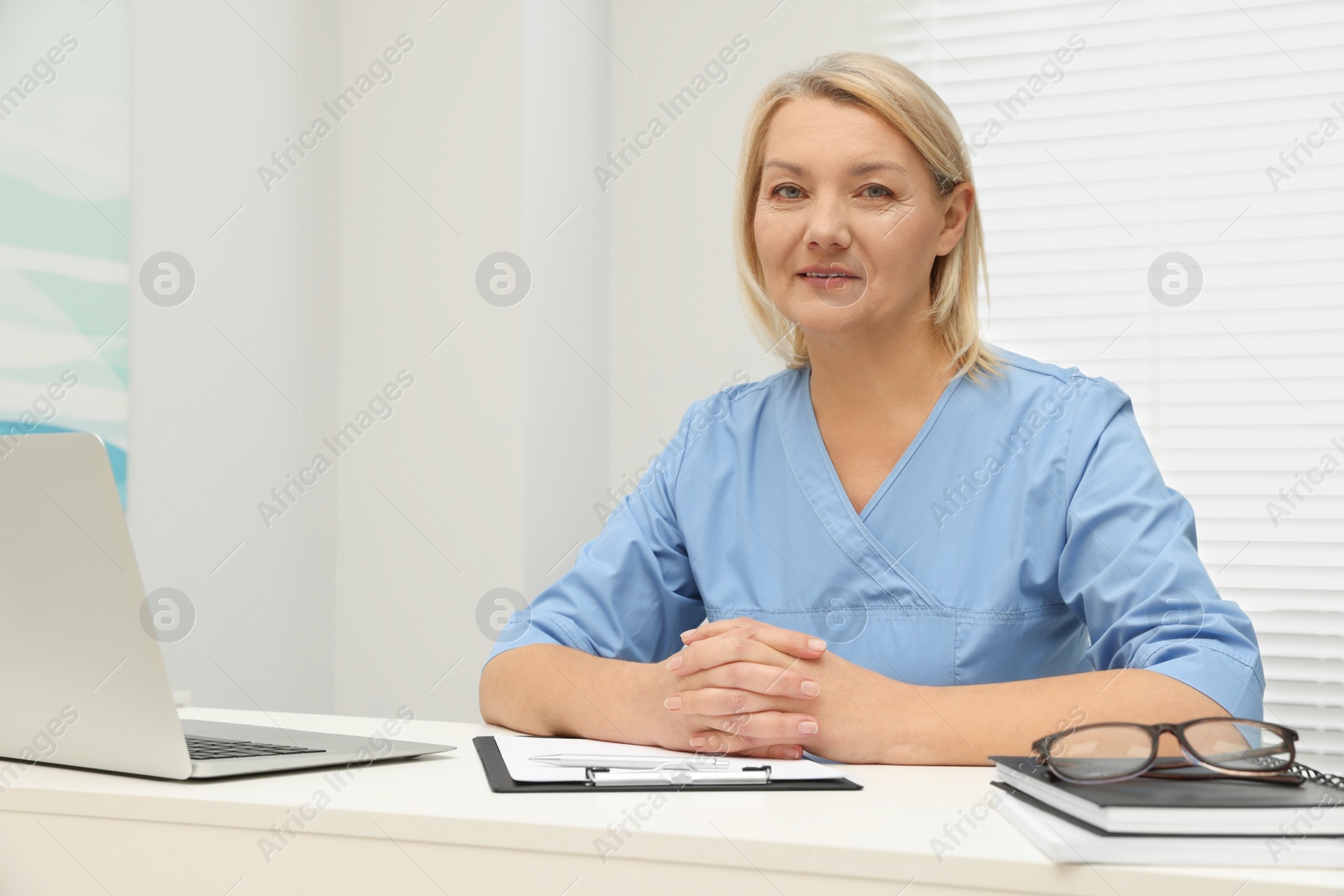 Photo of Doctor sitting at white table in clinic