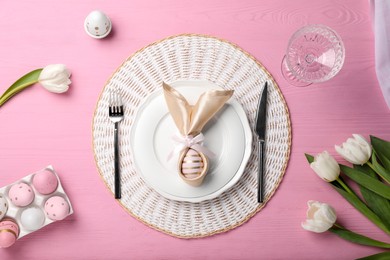 Photo of Festive table setting with painted eggs, plate and tulips, flat lay. Easter celebration
