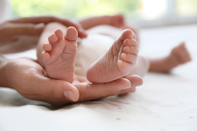 Mother and her newborn baby on bed, closeup