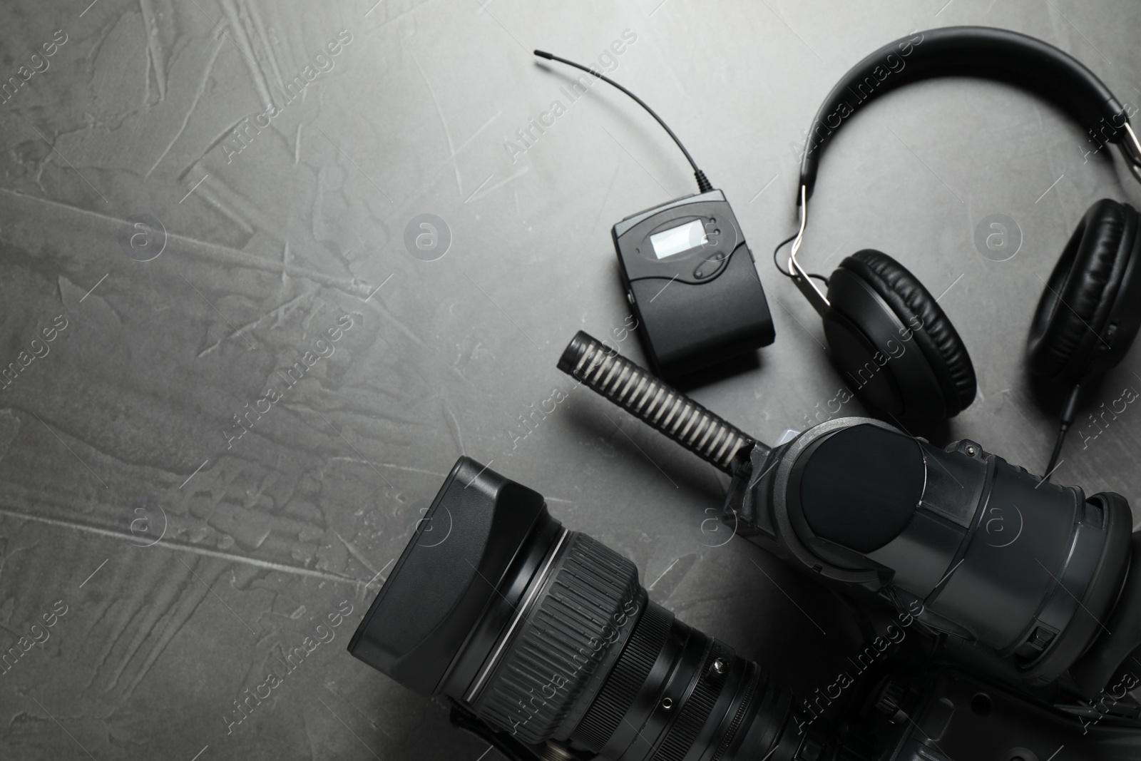 Photo of Flat lay composition with camera and video production equipment on grey stone background. Space for text