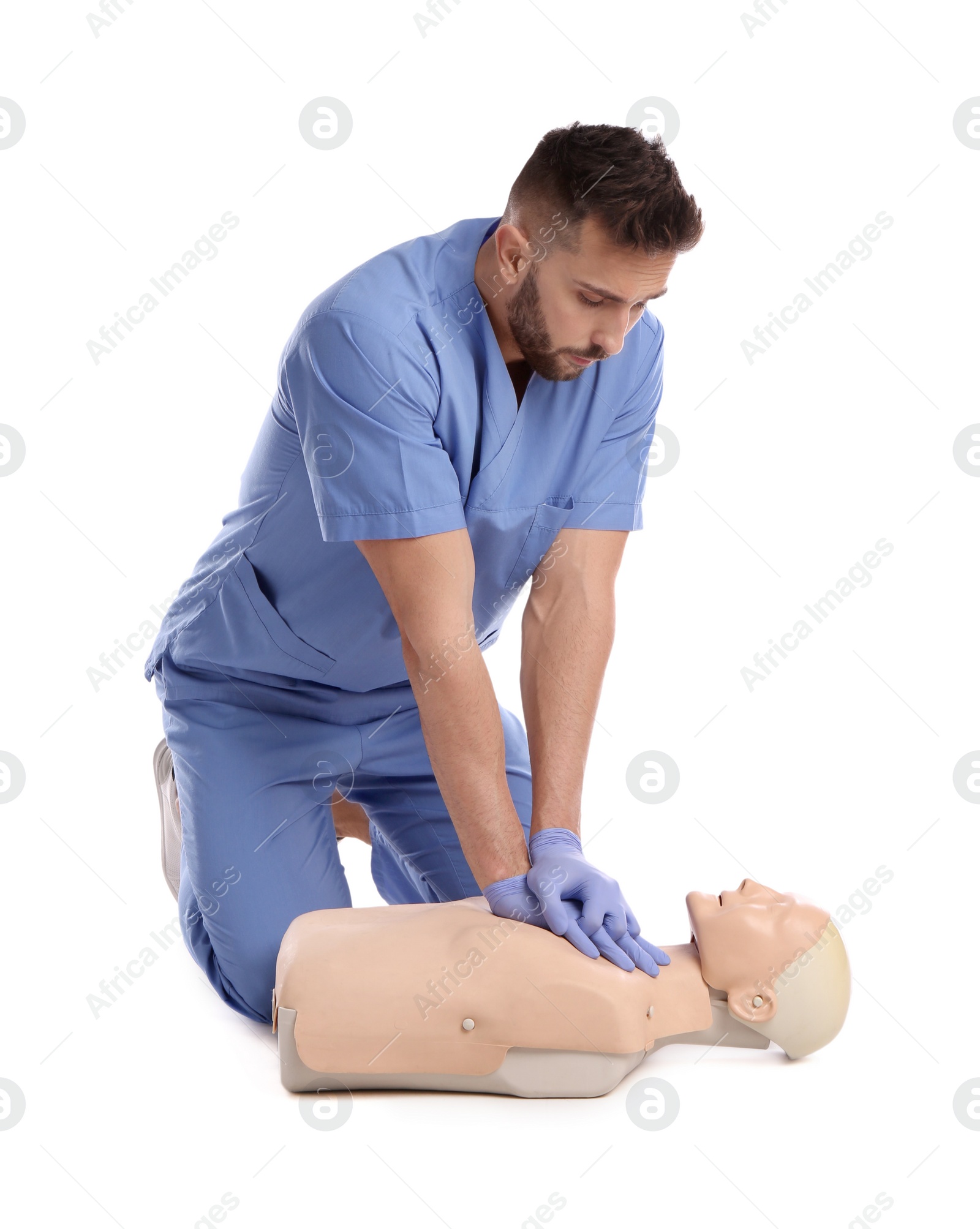 Photo of Doctor in uniform practicing first aid on mannequin against white background