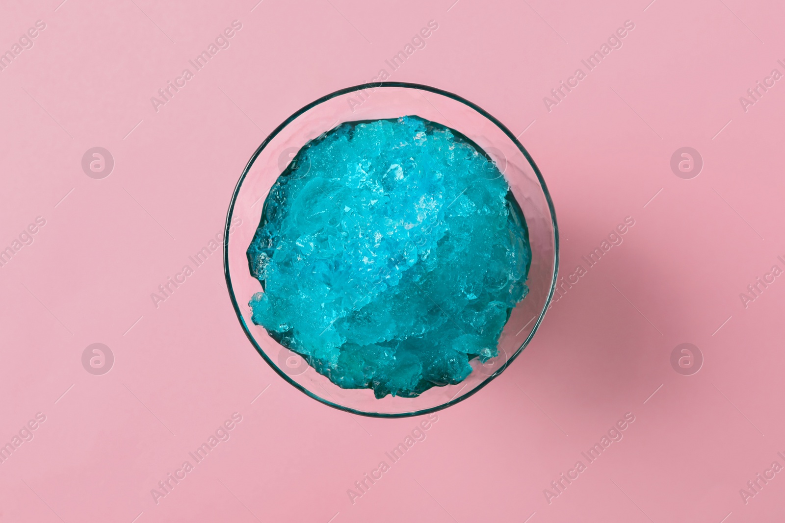 Photo of Shaving ice in glass dessert bowl on pink background, top view