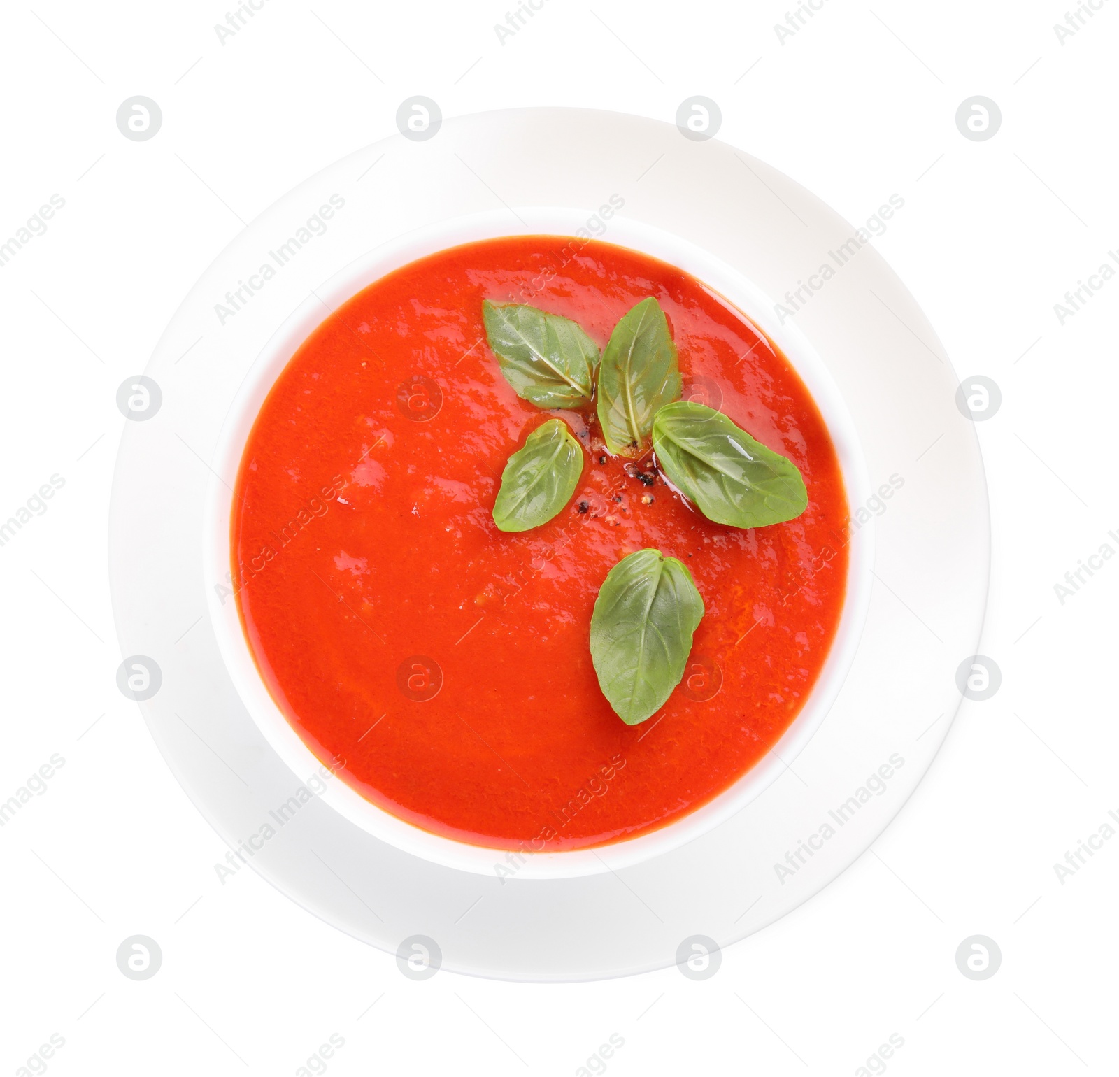 Photo of Delicious tomato cream soup in bowl isolated on white, top view