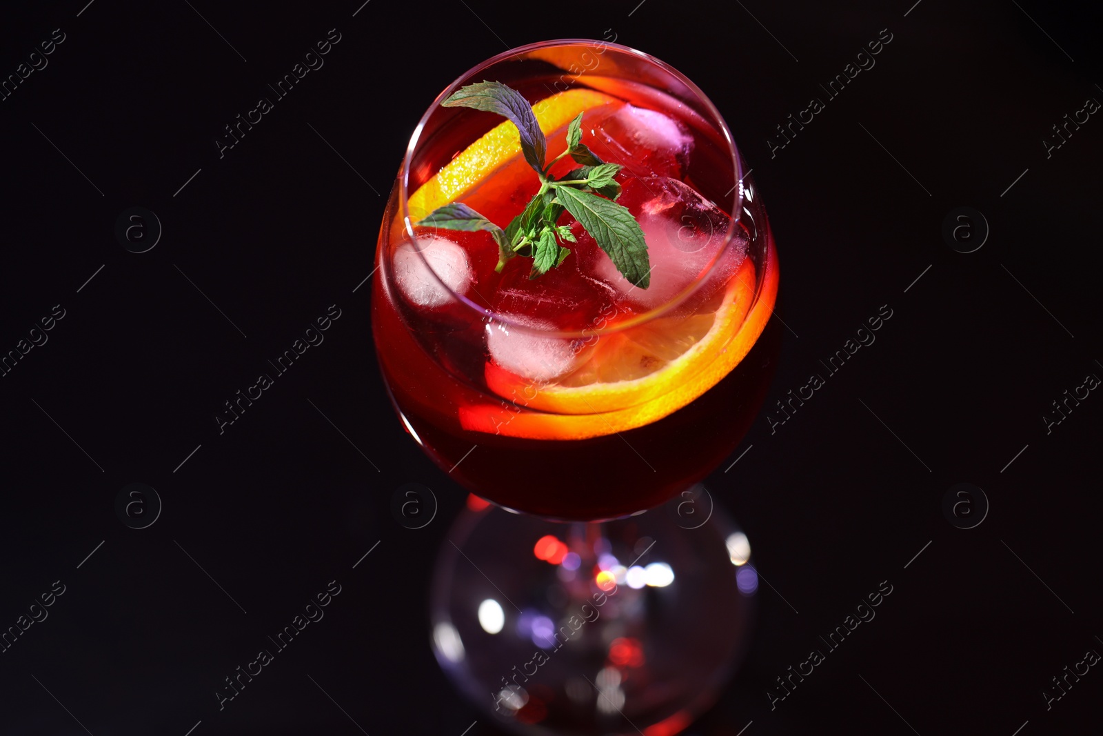 Photo of Glass of delicious refreshing sangria on black table, closeup