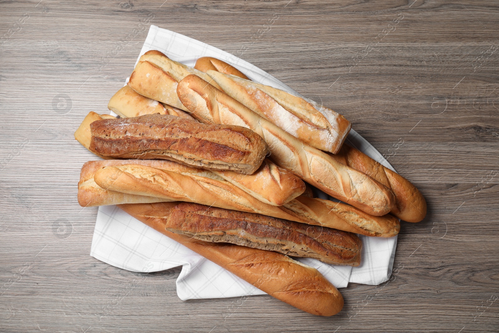 Photo of Different tasty baguettes on wooden table, top view