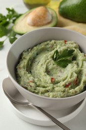 Photo of Delicious guacamole served on white table, closeup