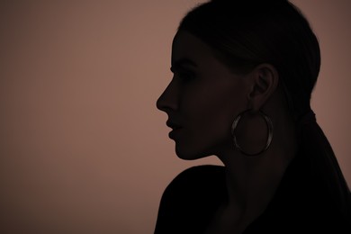 Image of Silhouette of woman on brown background, profile portrait. Space for text